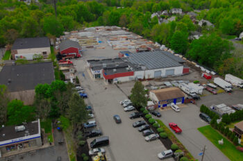 Aerial view of the Edison branch. There are various cars parked all over the parking lot and various buildings are shown.